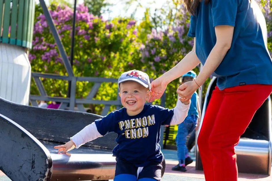 Happy child playing on a slide in a vibrant Russian park, enjoying a sunny day.