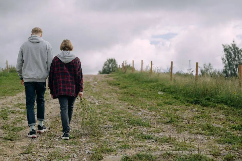 Two friends walking along a rural path in nature, enjoying the outdoors.
