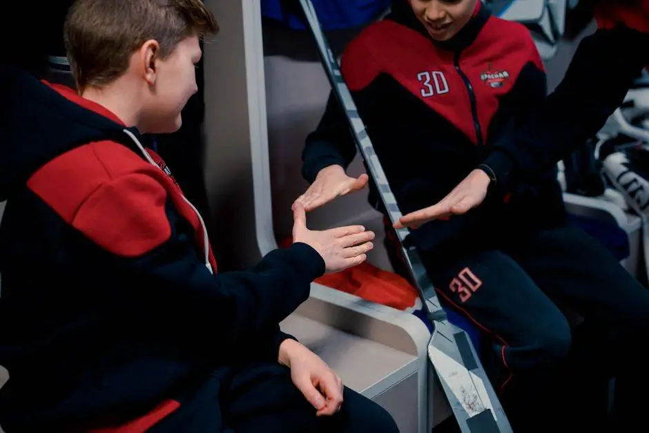 Teens in a locker room playing rock paper scissors before a hockey game, adding fun and camaraderie to the sport.
