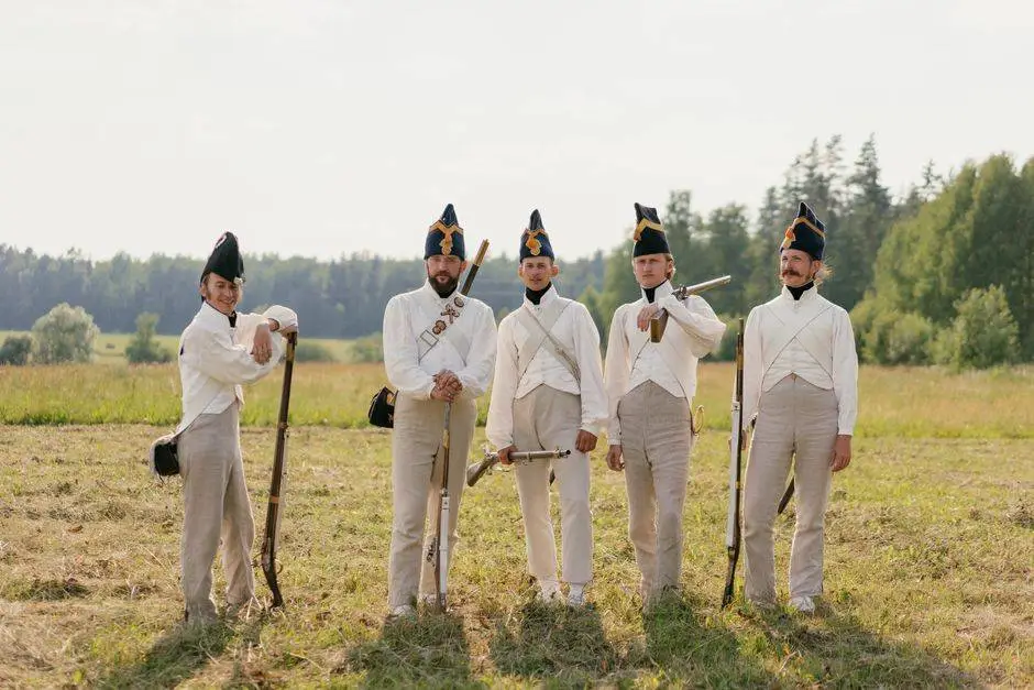 Group of men in Napoleonic uniforms posing outdoors in a historical reenactment.