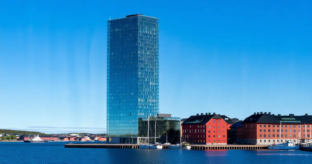 Moderni pilvenpiirtäjä kohoaa Pohjoismaiden kaupungin siluetissa sataman yläpuolella